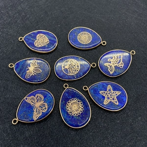 Detailed macro of Lapis Lazuli water drop pendants with golden Tree of Life and animal patterns
