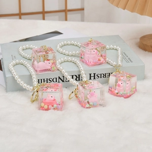 Close-up of creative liquid sand Capybara keychains with pink pig and pearl strap