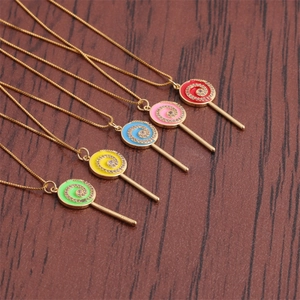 Détails de pendentifs sucettes colorés avec spirales dorées et cristaux étincelants