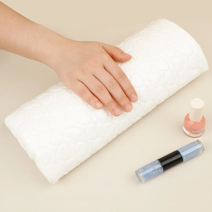 Close-up of a white heart-embossed PU leather manicure hand rest with hand support detail