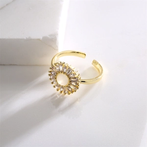 Macro shot of gold sunburst ring featuring rectangular cubic zirconia stones and open band