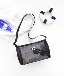 Cylindrical black mesh beach bag with large eyes pattern and summer vacation props