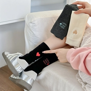 Detail of embroidered heart and 'Follow your heart' text on cotton crew socks