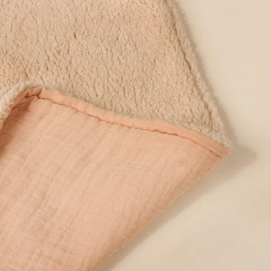 Macro detail of soft fleece lining and breathable muslin cotton fabric on baby blanket