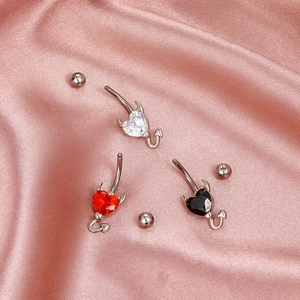 Three heart-shaped devil navel rings with white red and black cubic zirconia on pink silk