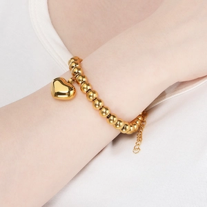 Minimalist 18K gold plated beaded bracelet featuring a polished heart charm on the wrist