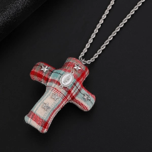 Détail d'un pendentif croix en tissu écossais gothique avec étoiles argentées