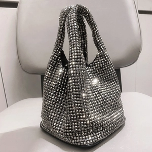 Close-up of sparkling silver rhinestone bucket bag with dense crystal embellishments