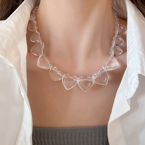 Close-up of transparent heart-shaped acrylic bead necklace worn on model neck