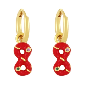 Macro detail of gold-plated infinity earrings with red enamel and zircon stones