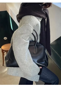 Close-up of a minimalist black leather handbag with a high-quality smooth texture for commuting
