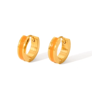 Close-up of golden stainless steel hoop earrings with orange enamel inlay details
