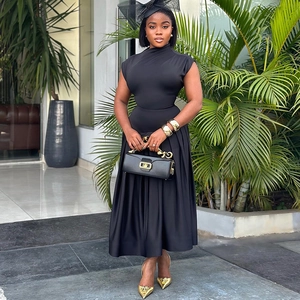Elegant sleeveless black pleated dress with cinched waist and full skirt street style view