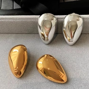 Abstract face portrait drop earrings in polished gold and silver metallic finish