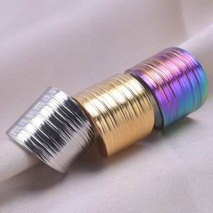 Dettaglio di tre anelli regolabili in acciaio inossidabile argento oro e motivo a righe arcobaleno
