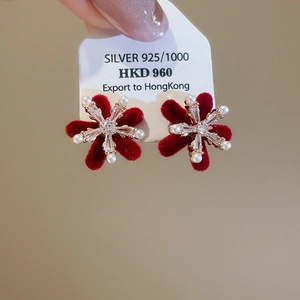 Macro shot of S925 silver snowflake earrings with red flocking, zircon, and pearls