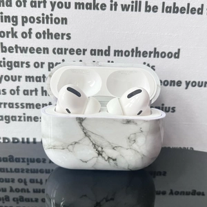Detail view of the white marble texture on the protective case for wireless earbuds
