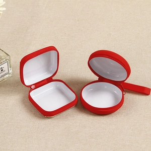 Detail of red cartoon coin purse with white lining and zipper closure for storage