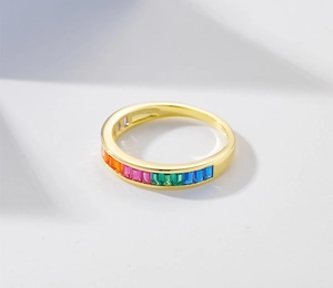 Detailed macro shot of a gold ring with rainbow rectangle cut gemstones in channel setting
