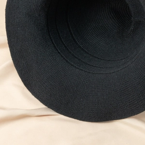 Close-up of black knitted witch hat showing detailed circular woven texture on brim