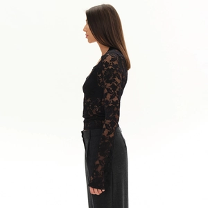 Side view of black floral lace long sleeve top with slim fit and sheer texture