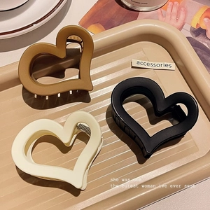 Matte acrylic heart-shaped hair claw clips in black, brown, and beige for ponytail styling