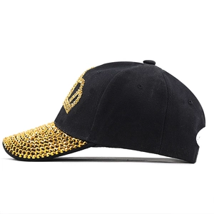 Detailansicht der schwarzen Baseballkappe mit goldenem Strass-Kronen und Schirmdekor