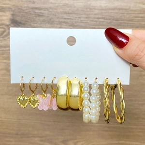 6-pair gold earring set with butterfly and heart pendants on display card