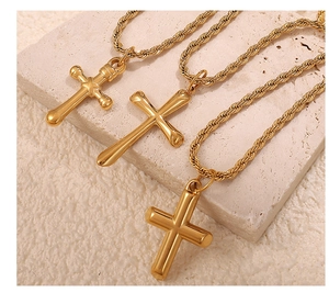 Detailed close-up of three gold cross pendants on rope chains over stone background