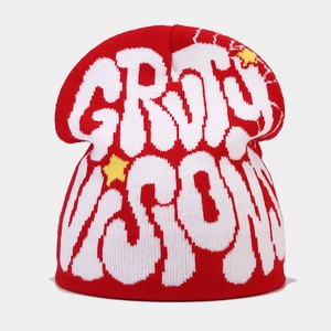 Detail of red knit beanie with white GRITY VISION jacquard lettering and yellow stars