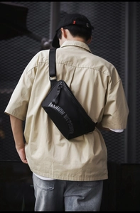 Détail de la sacoche noire utilitaire avec sangle réglable portée par le mannequin