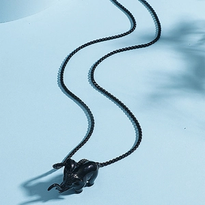 Hip hop black elephant pendant necklace with matching bead chain on textured background