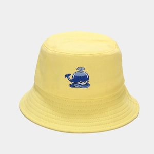 Dettaglio del ricamo balena blu su cappello a secchiello in cotone giallo con cuciture