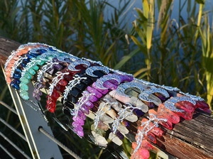 Detail of bohemian crystal cat ear crowns with moon and leaf motifs in various colors
