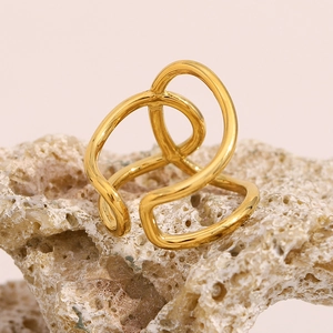 Macro detail of intertwined multi-layer 18K gold plated lines on a polished open ring