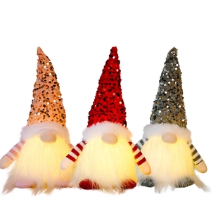 Three glowing Christmas gnomes with sequin hats in red, pink, and grey on white background