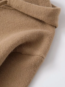 Macro shot of warm camel knit fabric showing fine texture and reinforced stitching