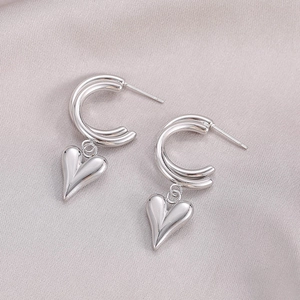 Orecchini vintage in argento a doppia C con pendente a cuore su sfondo di raso