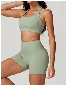 Dettaglio del set yoga verde salvia con reggiseno a vogatore e pantaloncini a vita alta
