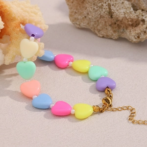 Detailed view of colorful acrylic heart beads on a bracelet with gold lobster clasp