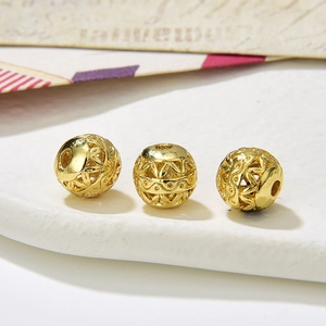 Macro shot of three vintage hollow golden filigree beads with intricate carved patterns