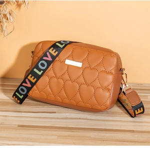 Detailed heart-quilted texture on brown camera bag with colorful LOVE shoulder strap