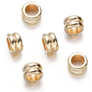 Macro detail of golden double-layer circular spacer beads for jewelry making
