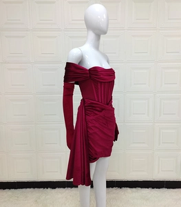 Détail d'une robe en velours bordeaux à épaules dénudées avec gants longs assortis
