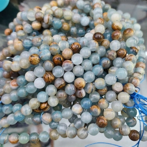 Strand of polished natural blue calcite round beads with diverse textures and colors