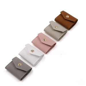 Detailed arrangement of soft leather jewelry pouches in five neutral tones with gold snaps