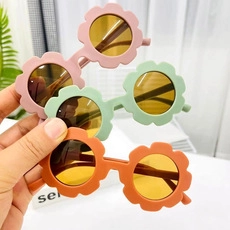 Tre paia di occhiali da sole per bambini a forma di fiore in rosa, verde e arancio opaco