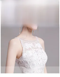 Détail du col rond avec dentelle délicate et petites perles blanches sur la robe de mariée