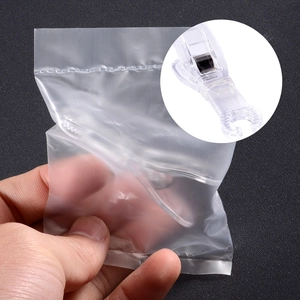 Macro view of clear acrylic piercing triangle clamp inside a sealed sterilization bag