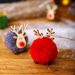 Close-up of wool felt reindeer ornaments with wooden antlers on festive snowy background